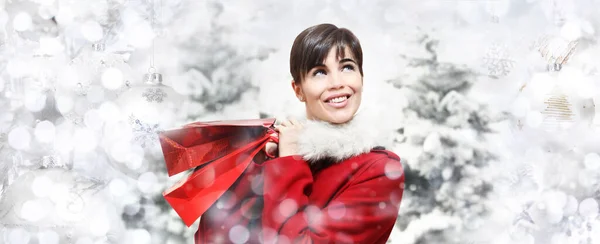 快乐的微笑着的女人 带着快乐的圣诞礼物袋 与树木和模糊的彩灯上的球隔离 促销购物 广告横幅海报或礼品卡模板 — 图库照片
