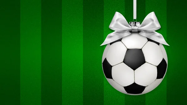 サッカーボールと明るいサテンリボン弓 サッカー場の緑の背景に 空のコピースペースのバナーテンプレートと陽気なクリスマスのギフトグリーティングカード クリスマスワールドカップトーナメントのコンセプト — ストック写真