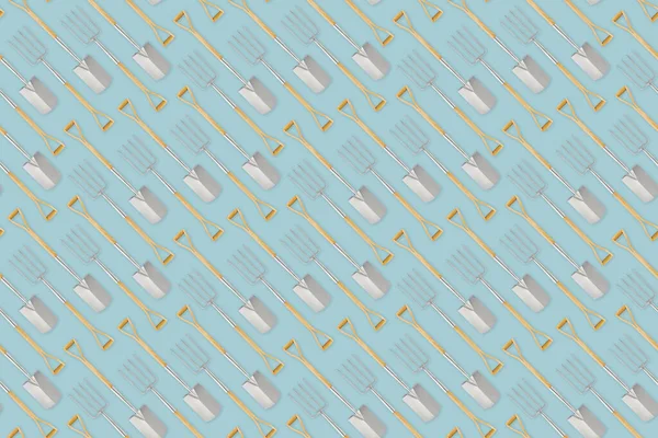 stock image Seamless pattern with gardening tool and garden equipment, spade and fork with wooden handle, isolated top view on light blue background. Wrapper template for greenhouse or flower shop.