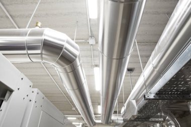 HVAC system pipes, handling heating, ventilation, air conditioning, and cooling, are located on the ceiling. This climate control system ensures the comfort of the rooms in the building. clipart