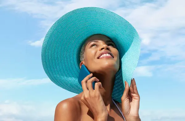 Happy Woman Beach Side Wearing Blue Sun Hat Using Mobile Stock Picture
