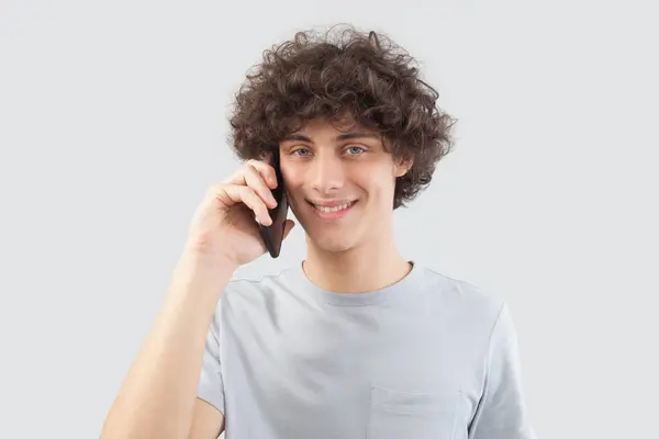 Young Handsome Man Smiles Uses His Smartphone Talking Listening Cellphone Stockfoto