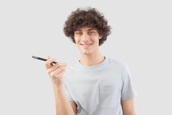 Young Handsome Man Smiles Uses His Smartphone Talking Listening Cellphone Rechtenvrije Stockafbeeldingen
