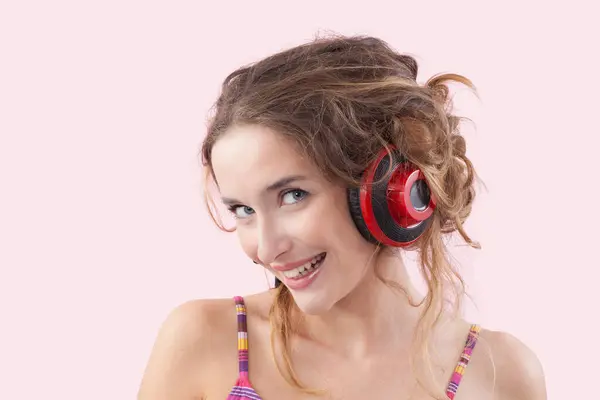Portret Młodej Uśmiechniętej Kobiety Słuchającej Muzyki Przez Czerwone Słuchawki Patrzącej Zdjęcia Stockowe bez tantiem