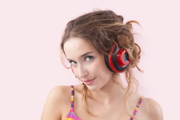 Portret Młodej Uśmiechniętej Kobiety Słuchającej Muzyki Przez Czerwone Słuchawki Patrzącej Obraz Stockowy