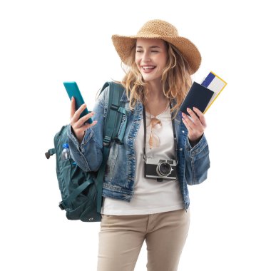 Akıllı telefonlu mutlu genç bayan turist, uçak biletiyle bir selfie çek, omuzlarında sırt çantası, beyaz arka planda izole edilmiş. Yaz tatili ya da seyahat etkeni kavramı