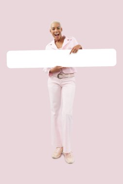 Gülümseyen Afrikalı kadın beyaz boş afiş gösteriyor, pembe arka planda izole edilmiş. Reklam tabelası. Mağaza ve AVM Billboard en iyi anlaşmaları veya Kara Cuma indirimi ve teklifi veya online alışveriş