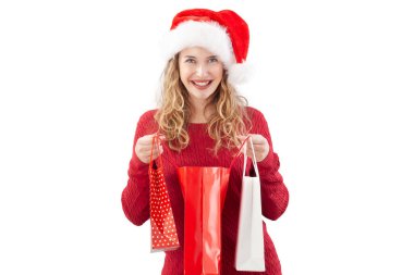 Gülümseyen sarışın genç bir kadın Noel Baba şapkası takıp beyaz bir arka planda Noel hediyesi paketi açıyor. Satılık ve promosyonlar, online alışveriş reklamları, ya da hediye kartları.