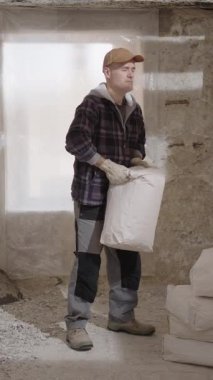 İnşaat işçisi inşaat alanında ağır bir çuvalı kaldırırken aniden sırt ağrısı ve kötü duruş nedeniyle gergin bir sırt yaralanması ağır iş sırasında düzgün bir duruşun önemi