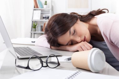Çok çalışan ve yorgun genç kız öğrenci ya da serbest çalışan, uzun saatler çalıştıktan, çalıştıktan ya da internette geçirdiği saatlerden sonra masasında uyuyan, dizüstü bilgisayarlar, defterler, kahve ve gözlüklerle çevrili.