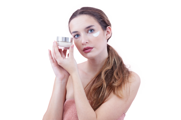 Cilt nemlendirici süren ve kameraya bakarken bir kavanoz krem tutan genç bir kadın. Cilt bakımı ve güzellik anlayışı. Arka planda izole edilmiş. Yüz bakımı, makyaj ve sağlıklı cilt