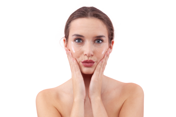 Makyajsız, göz bantlarının altına silikon takmış, kameraya bakan genç bir kadının portresi. Siyah halkalar için cilt konsepti, beyaz arkaplanda izole