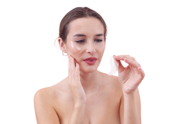 Doğal makyajlı genç bir kadının portresi, göz bantları altında silikon uyguluyor. Siyah halkalar için cilt konsepti, beyaz arkaplanda izole