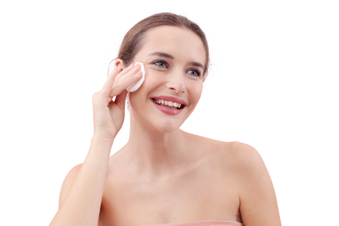 Gülümseyen genç bir kadın yüzünü pamuk ped ve mikiler suyuyla temizliyor. Cilt rutini, makyaj çıkarma, taze sağlıklı deri. Beyaz arka plan, güzellik ve hijyen kavramına izole edilmiş.