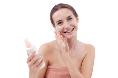 Gülümseyen genç bir kadın yüzünü pamuk ped ve mikiler suyuyla temizliyor. Cilt rutini, makyaj çıkarma, taze sağlıklı deri. Beyaz arka plan, güzellik ve hijyen kavramına izole edilmiş.