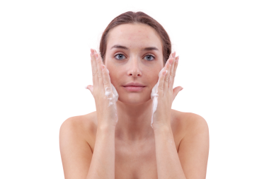 Yüzünü köpük temizleyiciyle temizleyen, ellerini köpükle kaplayan ve cildine süren genç bir kadın. Temiz ve sağlıklı yüz için cilt rutini. Beyaz arka planda izole edilmiş, akne bakımı