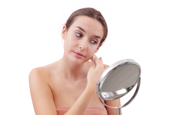 Genç bir kadın, aynanın önünde yüzünü pamuk pedlerle temizliyor ve suyu bodruma indiriyor. Cilt rutini, makyaj çıkarma, taze sağlıklı deri. Beyaz arka plan, güzellik ve hijyen kavramına izole edilmiş.