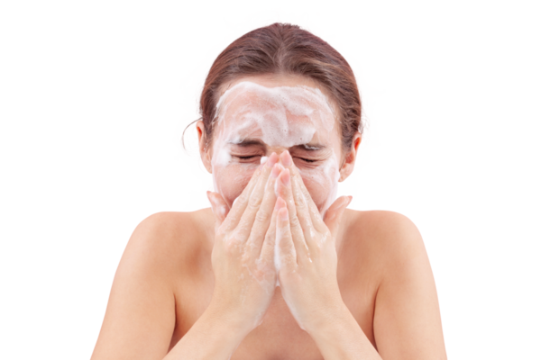 Yüzüne köpük bulaşmış ellerle yüzünü yıkayan genç bir kadının yakın çekimi. Temiz ve sağlıklı cilt için derin cilt temizleme rutini. Beyaz arka planda izole edilmiş, akne bakımı konsepti