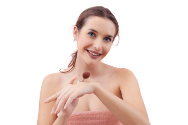 Kameraya bakarken allık sürmeden önce eline makyaj fırçası süren gülümseyen genç bir kadın. Temiz, asgari güzellik konsepti. Beyaz arkaplanda izole