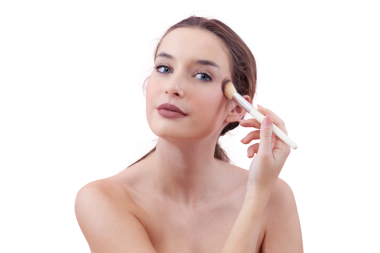 Mavi gözleriyle kameraya bakarken makyaj fırçasıyla allık süren gülümseyen genç bir kadının portresi. Temiz, asgari güzellik konsepti. Beyaz arkaplanda izole.