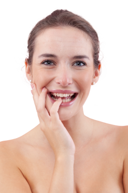 Yüzüne dokunurken kameraya gülen bir kadın. Yüzünde sivilceler, sivilceler ve kusurlar olan doğal bir ten gösteriyor. Cilt bakımından önce otantik bir kadın portresi. Beyazda izole edilmiş