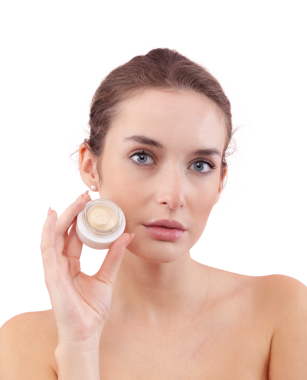 Makyajlı genç bir kadın yüzünde cam bir krem kavanozu tutuyor. Cilt bakımı ve güzellik tedavisi rutin konsepti. Beyaz arkaplanda izole