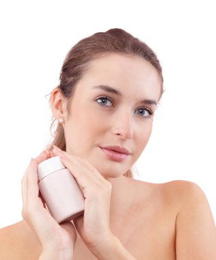 Makyajlı gülümseyen genç bir kadın yüzüne plastik bir makyaj kremi tutuyordu. Cilt bakımı ve güzellik tedavisi rutin konsepti. Beyaz arkaplanda izole