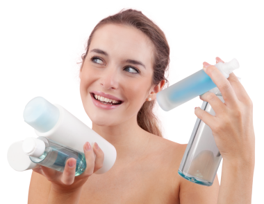 Elinde mikiler suyu ve duş jeli de dahil olmak üzere çeşitli cilt bakımı şişeleri ve banyo ürünleri tutan gülümseyen genç bir kadın. Günlük güzellik, temiz cilt ve hijyen konsepti. Beyaz arkaplanda izole