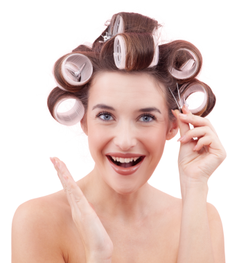 Saçında saç tokası ve saç bigudiyle gülümseyen genç bir kadının portresi. Kameraya bakarken bigudi uygulayan mutlu kız. Saç stili, güzellik ve özgüven. Beyaz arkaplanda izole