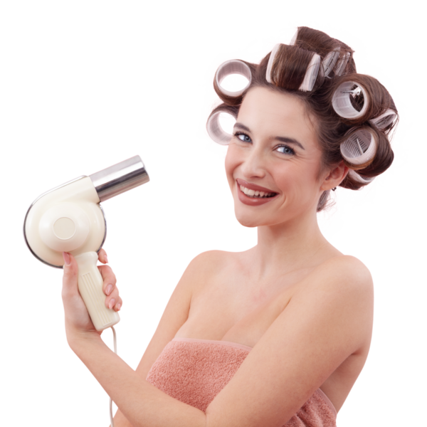 Saç bigudili, elinde saç kurutma makinesiyle gülümseyen genç bir kadının portresi. Banyo veya duştan sonra güzellik rutininin tadını çıkarıyor. Kişisel bakım ve saç modeli konsepti. Beyaz arkaplanda izole.