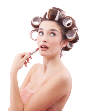 Makyaj, saç bigudiyle gülümseyen genç bir kadın ruj sürerken yandan mavi gözleriyle bakıyor. Saç stili, makyaj, güzellik ve kozmetik anlayışı. Beyaz arkaplanda izole