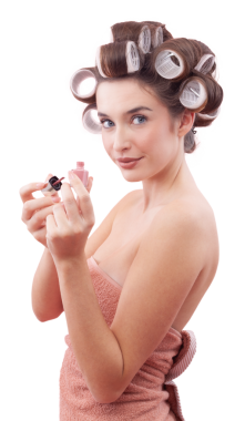 Mavi gözleriyle kameraya bakarken tırnak cilası süren saç bigudiyle gülümseyen genç bir kadın. Saç stili, makyaj, güzellik ve kozmetik anlayışı. Beyaz arkaplanda izole