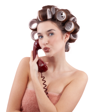 Saç bigudileri olan bir kadın kameraya öpücük gönderirken antika bir telefon kullanıyor. Saç stili, makyaj, güzellik ve kozmetik anlayışı. Muhtemelen kuaför randevusu alıyorum. Beyazda izole edilmiş