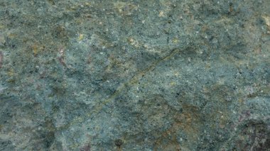 Engebeli, çatlak ve gözenekli toprak dokusunun detaylı yakın çekimi. Tasarım, jeoloji veya soyut sanat projeleri için doğal ve yıpranmış bir arkaplan sunan çatlakların ve küçük deliklerin karmaşık desenleri.