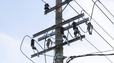 Elektrik kabloları, yalıtıcılar ve temiz bir gökyüzüne karşı elektrik donanımı olan beton elektrik direği. Temel enerji altyapısı ve dağılımı.