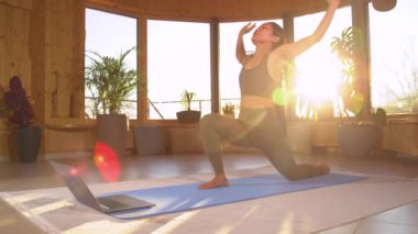Güzel bir Asyalı kadın evde yoga dersini takip ediyor. Çevrimiçi temel yoga kursunu izlerken güneş selamı veren genç bir bayan. Kadınların sağlıklı alışkanlıkları var..