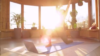İnternetteki yogadan sonra öne doğru hareketli spor yapan Asyalı kadın. Güzel Filipinli kadın evde hilal hareketli yoga pozu veriyor. Sağlıklı yaşam tarzı kavramını yaşamak.