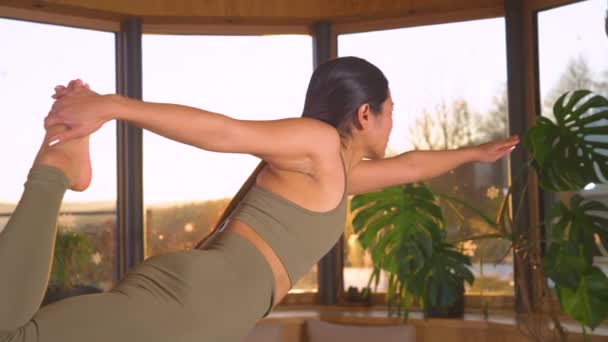 Slow Motion Close 黄金の夕日の光の中でShivaポーズを踊るスポーツアジアの女性 若いアジアの女性は自宅でヨガの練習をしています バランスと柔軟性のための健康的な屋内レジャー活動 — ストック動画