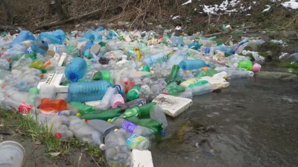 Tirana Albania 2022年3月 巨大なペットボトルの浮遊山の下を流れる川 川の端で捕獲された様々な廃棄物の巨大な山 ゴミ捨て場は川の自然を汚染 — ストック動画