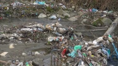 Etrafı sayısız plastik atıkla çevrili akan nehrin manzarası. Nehir ve kıyılarının uygunsuz plastik atık imhası çevresel bozulmaya yol açıyor..