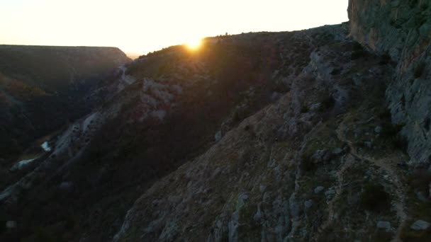 登山後の日没時に峡谷を離れる登山者の認識できないグループ 日の出には川の渓谷をハイキングする人々 美しい自然環境の中での冒険活動の後の一日の終わり — ストック動画