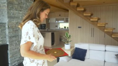 Güzel kadın feng shui uygulayıcısı lokasyonda luo pan pusula kullanıyor. İç mekanda feng shui analizi yapan genç bir kadın. Dengeli ev yaşam alanı tasarımı için enerji akışı düzenlemeleri.