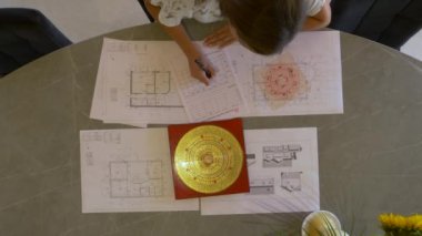 Genç bayan analiz ediyor ve ev yapımı için feng shui planı yapıyor. Feng shui uzmanı dengeli ev ve verimli ev iç tasarım düzenlemeleri için enerji akışı dağılımını analiz ediyor.