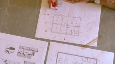 Genç bir kadın enerji akışı analizi için feng shui ev planını bitiriyor. Genç bir kadın, konutların dengeli feng shui iç tasarım düzenlemesi için enerji dağıtımını analiz ediyor.
