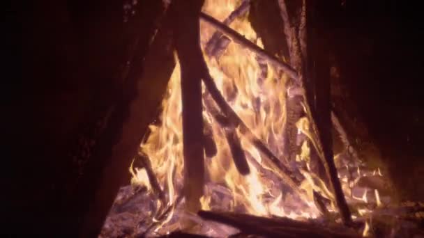 慢动作 燃烧的柴火放在黑暗中闪耀的篝火中 相对照的是在黑色背景下燃烧的原木 一团炽热的火焰和烟雾缠绕在木制的残余物上 — 图库视频影像