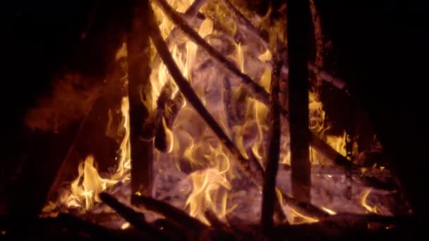 スローモーション 薪の炎の部分は たき火やにこやかなメンバーに積み上げ 黒い背景に燃えるログの高いコントラストビュー 薪の周りを炎と煙が渦巻く — ストック動画