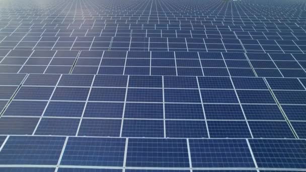空気発電のためのソーラーコレクターを並べた無限のパターン 持続可能なエネルギー生産のための太陽電池パネルの広大なフィールドを飛び越える 持続可能な未来のための近代的な技術利用 — ストック動画