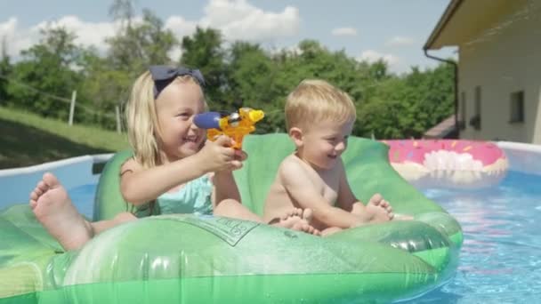 Close Cheerful Brother Sister Floating Pool Playing Water Pistol Water — Stock Video