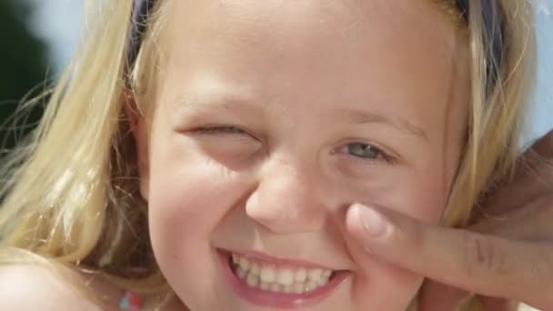 Κοντινό Πλάνο Εφαρμόζοντας Προστατευτική Αντηλιακή Κρέμα Ένα Χαμογελαστό Πρόσωπο Αξιολάτρευτο — Αρχείο Βίντεο