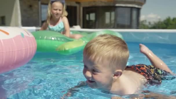 Cerrar Niño Sonriente Flotando Piscina Del Patio Trasero Aprendiendo Nadar — Vídeos de Stock